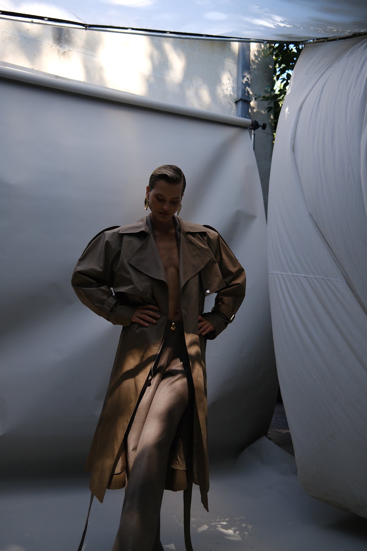 Beige neutral green trench coat crafted from a cotton-blend fabric with contrasting cupro detailing and refined hardware. Finished with classic button fastening, this timeless trench is designed for elevated everyday dressing, city styling and transitional cold-weather layering.