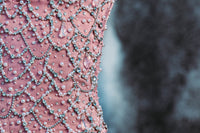 Soft pink corset crafted from 100% viscose, featuring delicate eyelet detailing, custom hand-embroidered detailing and a structured fitted silhouette. Finished with a zip fastening. Designed for romantic eveningwear, special occasions, celebrations and statement winter