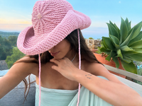 Hand-crocheted baby pink cotton sun hat with beaded sunburst embroidery and an oversized brim, the perfect luxury accessory for summer holidays and beach vacations.