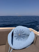 Hand-crocheted baby blue cotton sun hat with beaded sunburst embroidery and an oversized brim, the perfect luxury accessory for summer holidays and beach vacations.