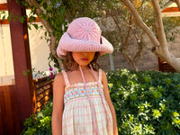 Hand-crocheted baby pink cotton sun hat with beaded sunburst embroidery and an oversized brim, the perfect luxury accessory for summer holidays and beach vacations.