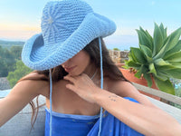 Hand-crocheted baby blue cotton sun hat with beaded sunburst embroidery and an oversized brim, the perfect luxury accessory for summer holidays and beach vacations.