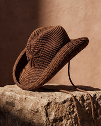 Hand-crocheted chocolate brown cotton sun hat with beaded sunburst embroidery and an oversized brim, the perfect luxury accessory for summer holidays and beach vacations.