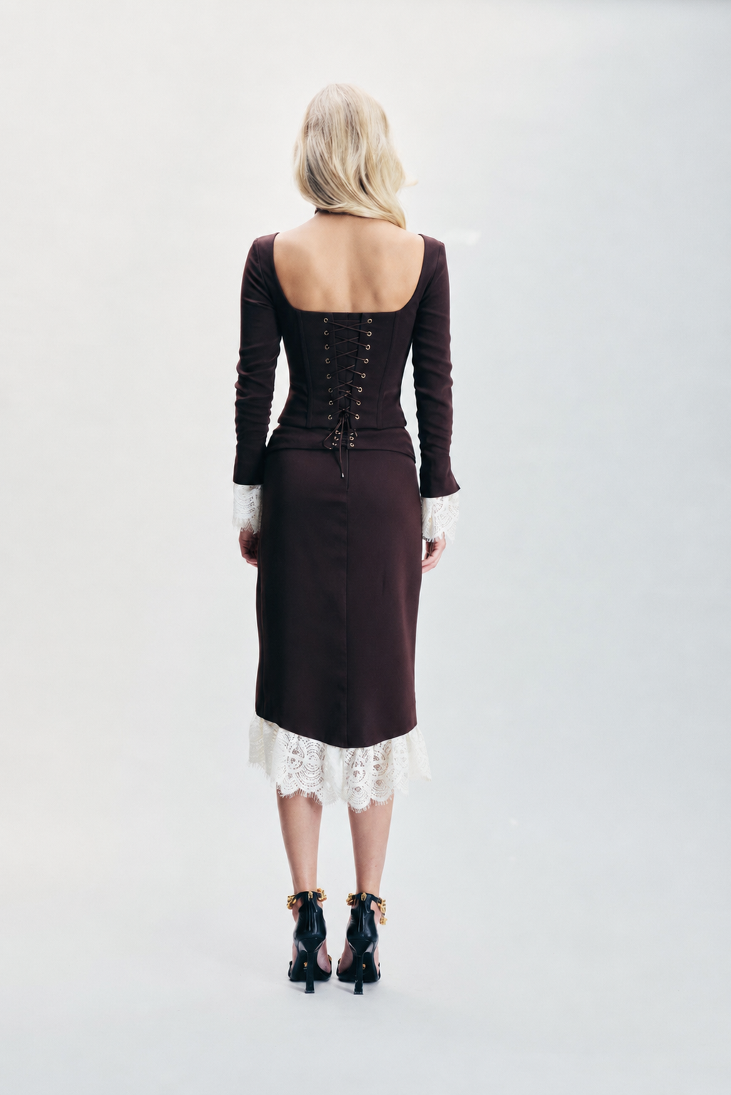 Chocolate brown Moroccan crepe skirt featuring contrasting ecru lace detailing, eyelet accents and a statement belt buckle. Designed with a sophisticated silhouette for effortless day-to-night styling, dinners, special occasions and elevated winter looks.