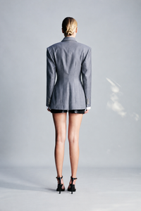 Gray wool-blend blazer featuring a structured tailored silhouette, defined shoulder pads and classic button fastening. Designed for polished day-to-night dressing, modern workwear, sophisticated occasions and elevated winter tailoring.
