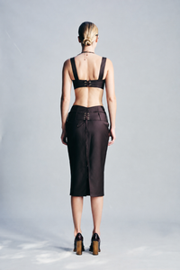 Chocolate brown skirt crafted from 100% wool with a structured silhouette, refined eyelet detailing and a statement belt buckle. Designed for sophisticated winter outfits, dinners, special occasions and elevated evening dressing.